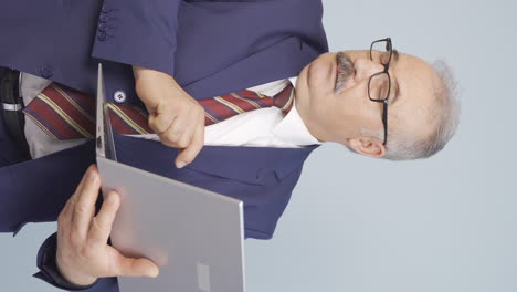 Vertical-video-of-Old-businessman-looking-at-laptop-with-scared-expression.
